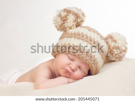Sweet sleeping newborn with knitted pom pom hat