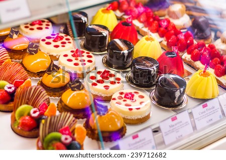 Pastry shop with variety of donuts, jelly beans, muffins, creme brulee, cakes with fruits and berries