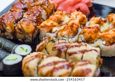 Assortment of delicious fresh, tempura and baked sushi maki with salmon, eel, cucumber, avocado, scrambled eggs, shrimp and unagi sauce