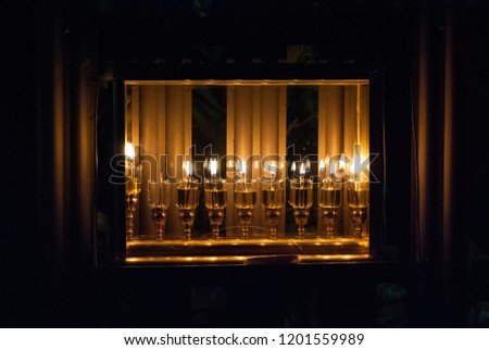 A Jewish tradition in Hanuka holiday is to put the lighted Hanuka\'s Menorah near the windows and even in glass boxes outdoor as shown in the pictures. Each day we light one more candle up to 8 candles