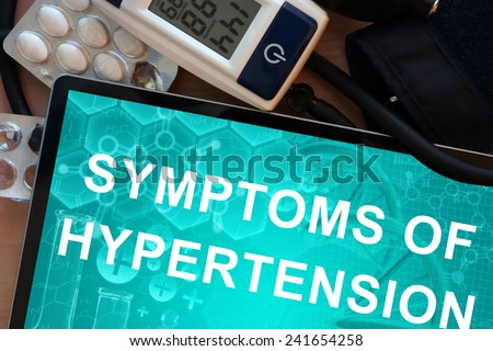 Tablet with the words symptoms of hypertension and Electronic blood pressure monitor