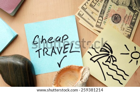 Cheap travel paper on a table with money