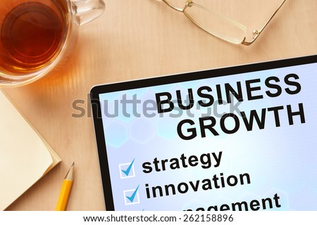 Tablet with words business growth. Business concept.
