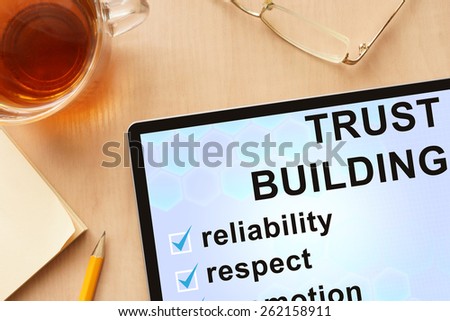 Tablet with words  trust building . Business concept.