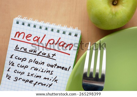 Paper with meal plan and  apple. Diet concept.
