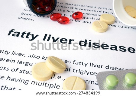 Paper with fatty liver disease and pills. Medical concept.