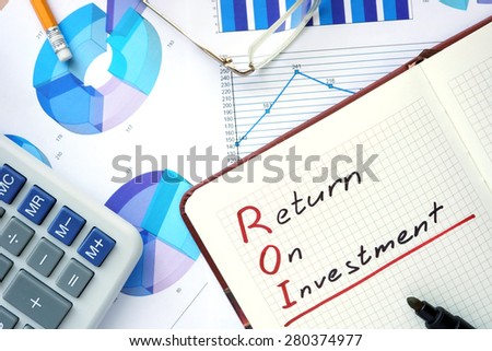 Notepad with words ROI return on investment  concept and marker.