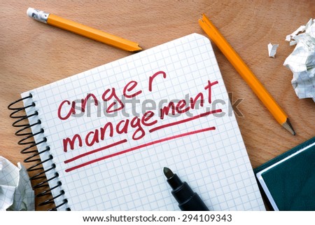 Notepad with anger management on office wooden table.