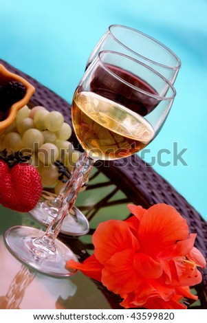 Different types of wine and berries by swiming pool