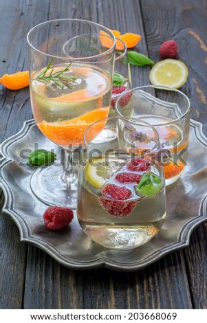 Raspberry basil Cocktail, apricot rosemary cocktail and apricot lavender cocktail with sparkling white wine and elderberry syrup on a vintage metal serving plate placed on the wooden surface