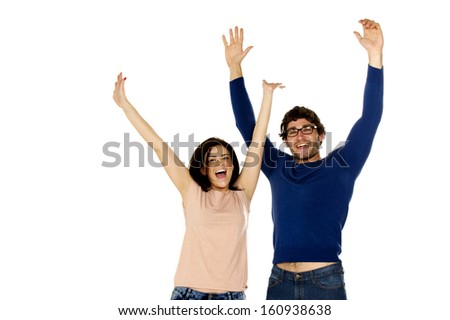 Attractive dark haired couple stood cheering and celebrating isolated on a white background