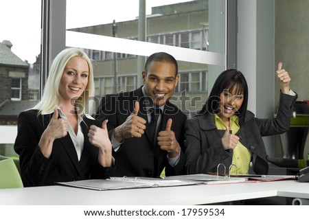 Business people in a meeting giving the thumbs up