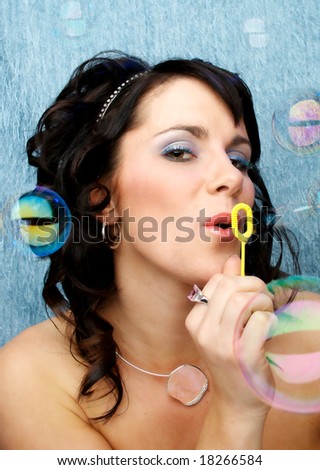 Beautiful woman looking at camera blowing bubbles