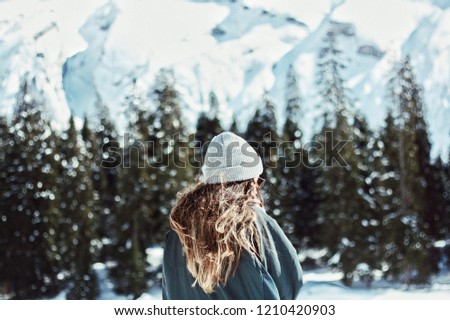 young girl with long hair and beanie hat in beautiful winter setting