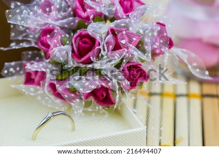 Engagement ring surrounded by bouquets of flowers and sweets