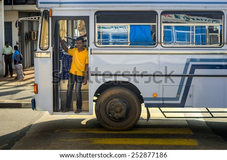 DIKWELLA, SRI LANKA - JANUARY 2, 2015: Man in a regular public bus near the  Dikwella. Buses are the Sri Lankan principal mode of public transport.