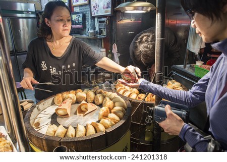Taipei, Taiwan - November 23, 2014: Vendor sells pepper pastry cake, a kind of snack popular in night market, at Shilin Night Market.