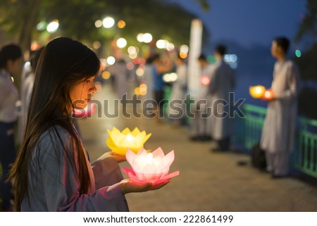 Hanoi, Vietnam - Oct 10, 2014: Buddhists hold flower garlands and colored lanterns for celebrating Buddha\'s birthday organised at Tran Quoc temple