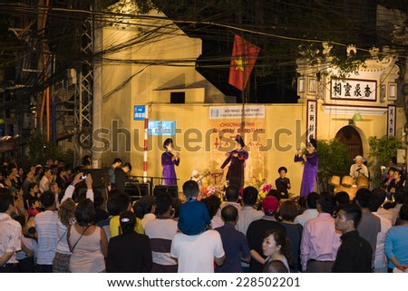 Hanoi, Vietnam - Nov 2, 2014: Tourist watch a free show of ancient folk music and song on Ma May street, old quarter of Hanoi