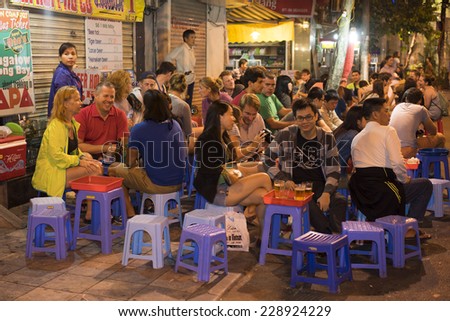 Hanoi, Vietnam - Nov 2, 2014: People drink beer on street at night in old quarter, center of Hanoi. Drinking beer on street is one of the most special culture of Hanoi.
