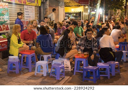 Hanoi, Vietnam - Nov 2, 2014: People drink beer on street at night in old quarter, center of Hanoi. Drinking beer on street is one of the most special culture of Hanoi.