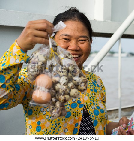 An Giang, Vietnam - Nov 29, 2014: Close-up shot of a rural woman selling boiled quail egg on passenger ferry in Tien river, Mekong delta