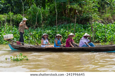 An Giang, Vietnam - Nov 29, 2014: Tourism rowing boat carries tourists wearing Vietnamese conical hat on Tien river, Mekong delta, southern Vietnam