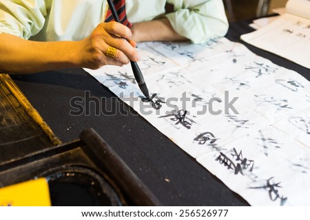 Calligrapher writing words on paper. Calligraphy is old culture of Vietnam