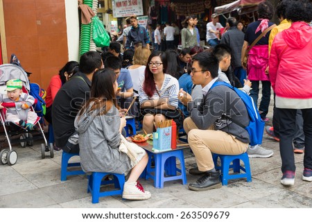 Hanoi, Vietnam - Mar 15, 2015: Tea stall on Hoan Kiem street - the shortest street in Hanoi. People sit on small plastic seat having coffee, tea or fast food...on sidewalk