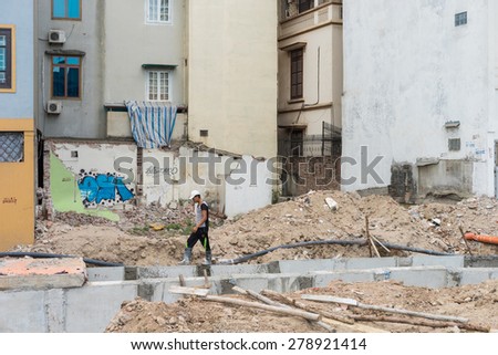 Hanoi, Vietnam - Apr 28, 2015: A man walking on ruin of demolished house by under construction urban drain in Xuan Thuy street