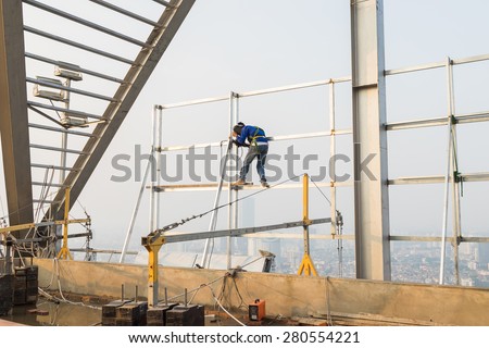 Asian worker weld on top of high building without scaffolding, low safety working condition