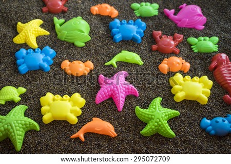 Plastic sea animals on man made sand. Children toys
