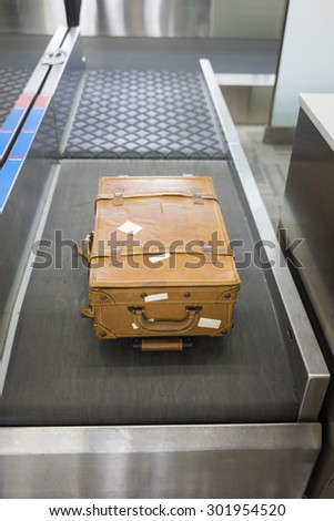 Big leather suitcase at check-in desk at airport