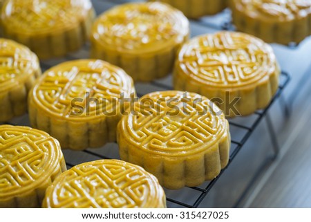 Moon-cake for Chinese and Vietnamese traditional mid-autumn festival in every full moon lunar August. Placed on tray against wooden background