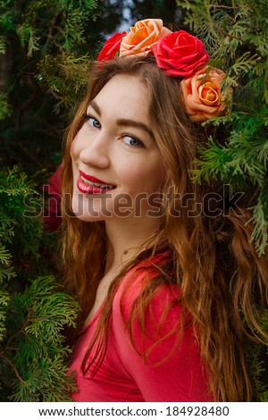 Girl with roses Girl in pink clothes with a wreath of roses on her head stay at juniper