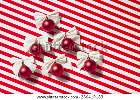 Group red Christmas balls lie in the form of a christmas tree on a red-white background