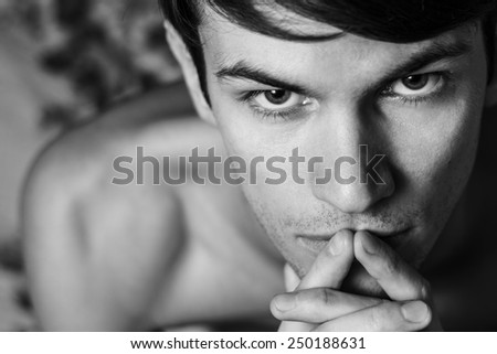 Close up of male head shot. Touching lips. Black and white portrait.