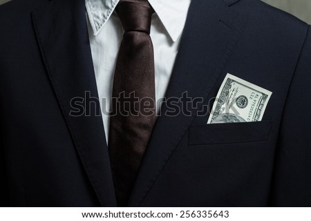 Close up of money in male suit pocket.