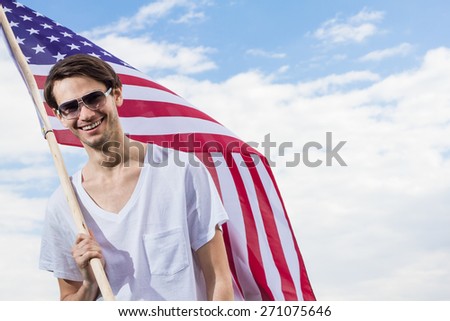 Happy man with american flag on sky background.