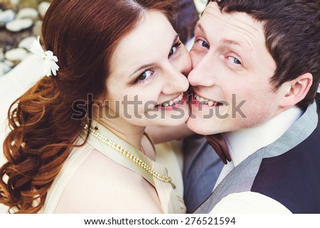 Portrait of beautiful young smiling groom and wife.