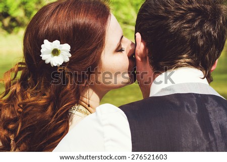 Portrait of beautiful young husband and wife. Woman kissing man.