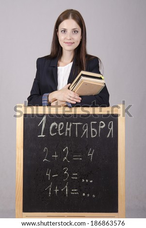 Portrait of the teacher. In the hands of the teachers of the book, before the teacher stands Board where it is written on September 1 and examples from mathematics
