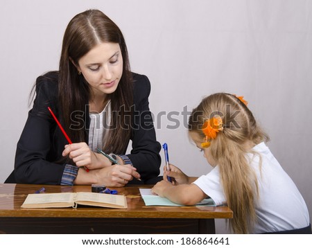 At the table sat a teacher and a student. Student teaches lessons, the teacher helps.
