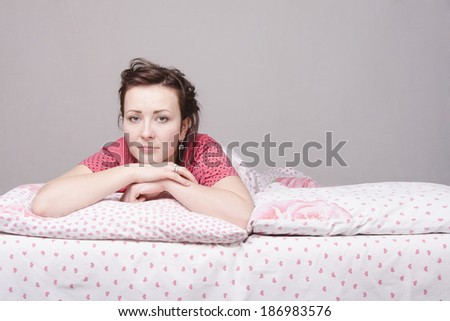 A young girl lying in bed one on one half