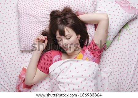 Young girl sleeping in bed covered with a blanket