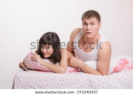 Young couple with money lying in bed