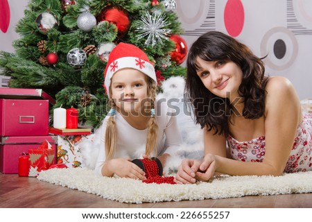 Mum and daughter lie on the five-year rug Christmas tree