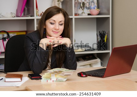 The girl at desk looking a stack of money