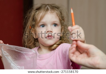 Girl takes from the hands of moms pencil