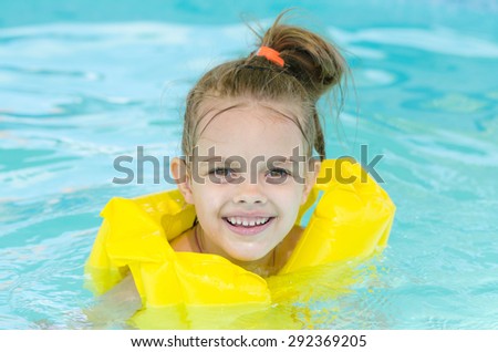 Six year old girl Europeans bathed in a small suburban poolPortrait of a smiling girl in a swimming pool